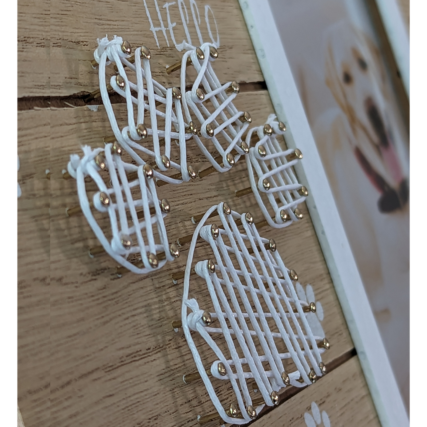 a close up of the White string art in the shape of a dog paw print on the pet memorial photo frame
